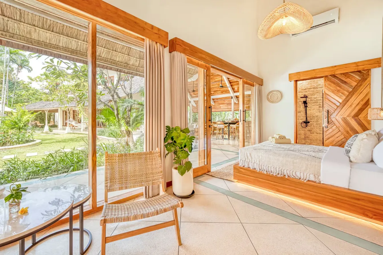 Private bedroom still and cool, light filtering through tropical leaves