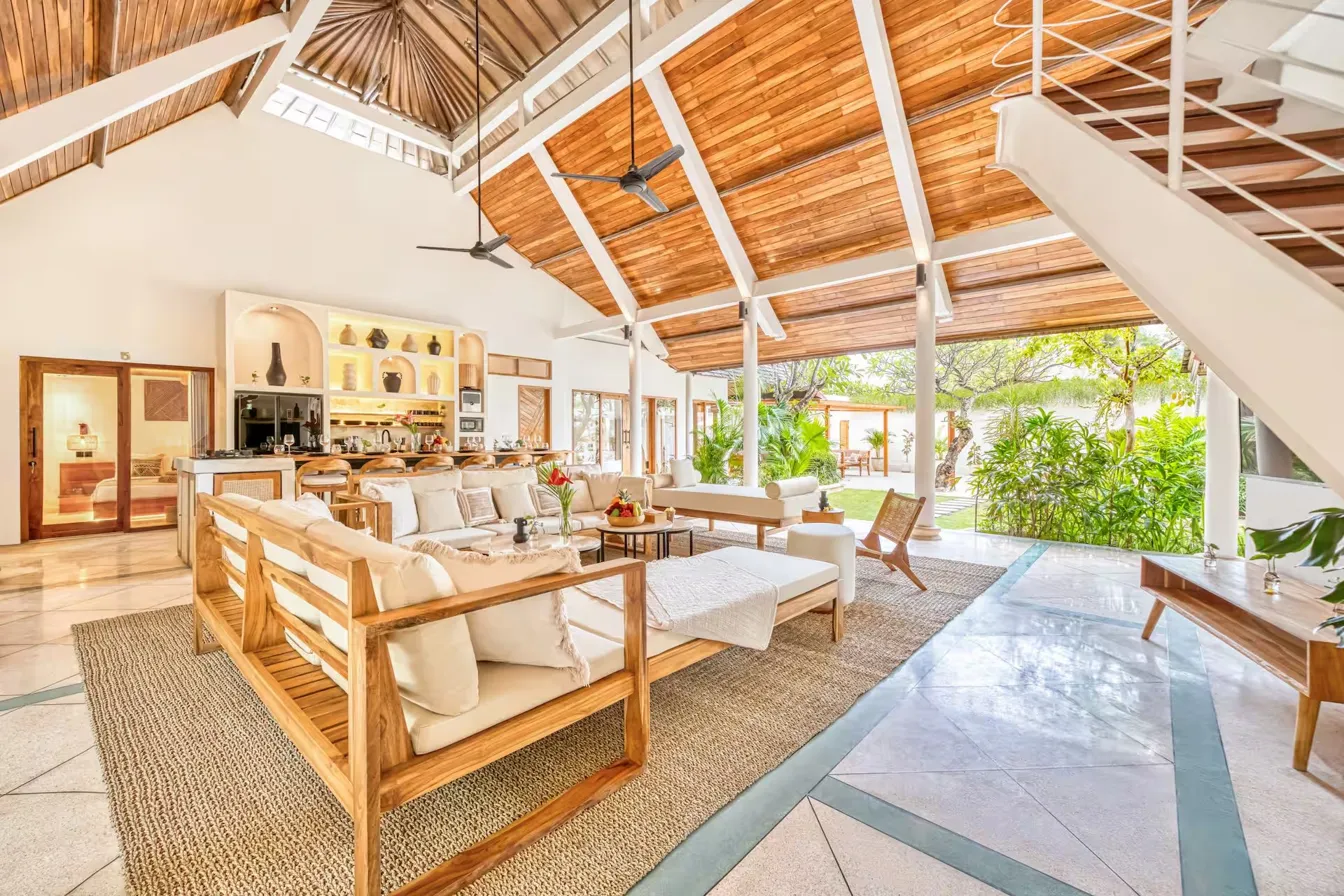 Sun-drenched open living area with high ceilings and garden views beyond
