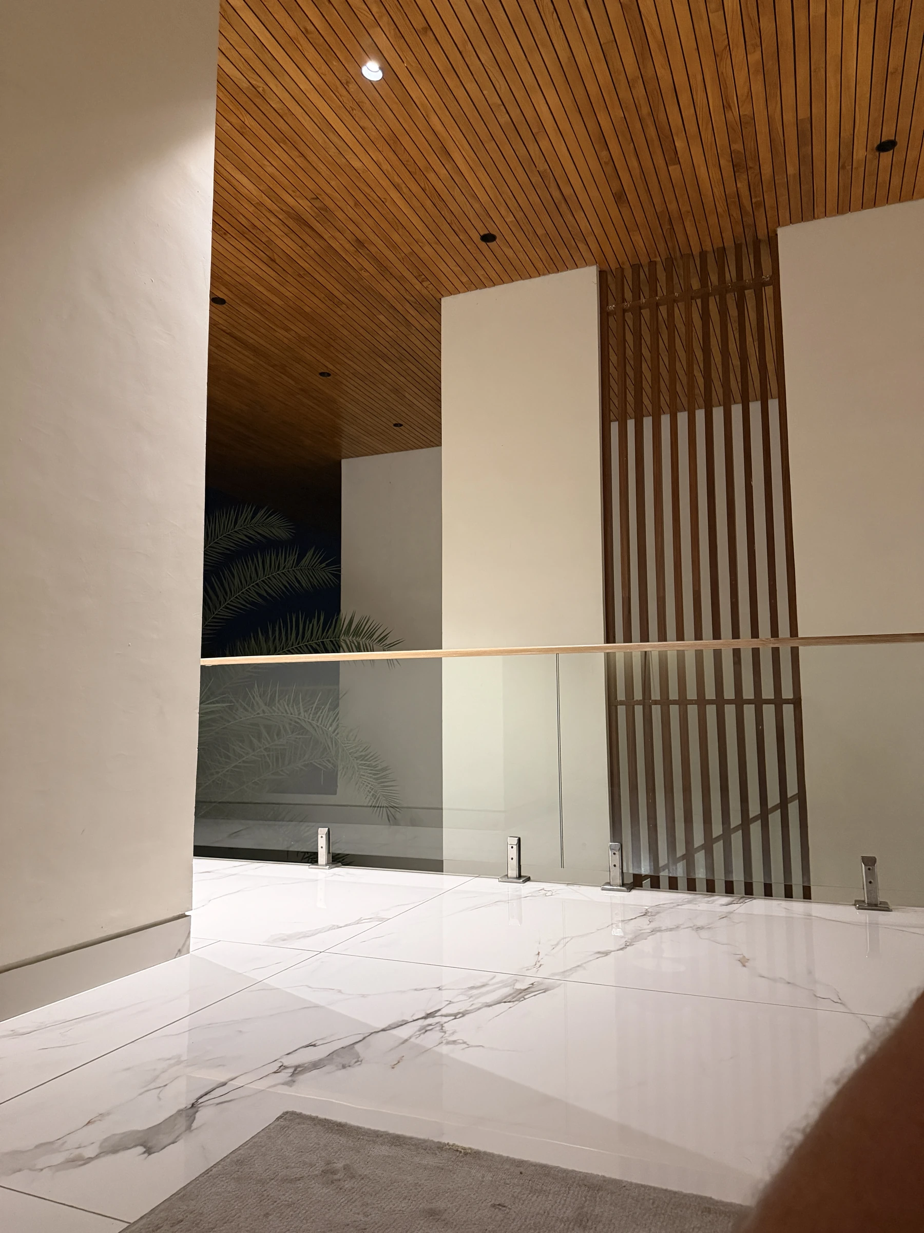 Holzlamellen, Naturstein und Glas im ruhigen Innenbereich der Residence auf Bali