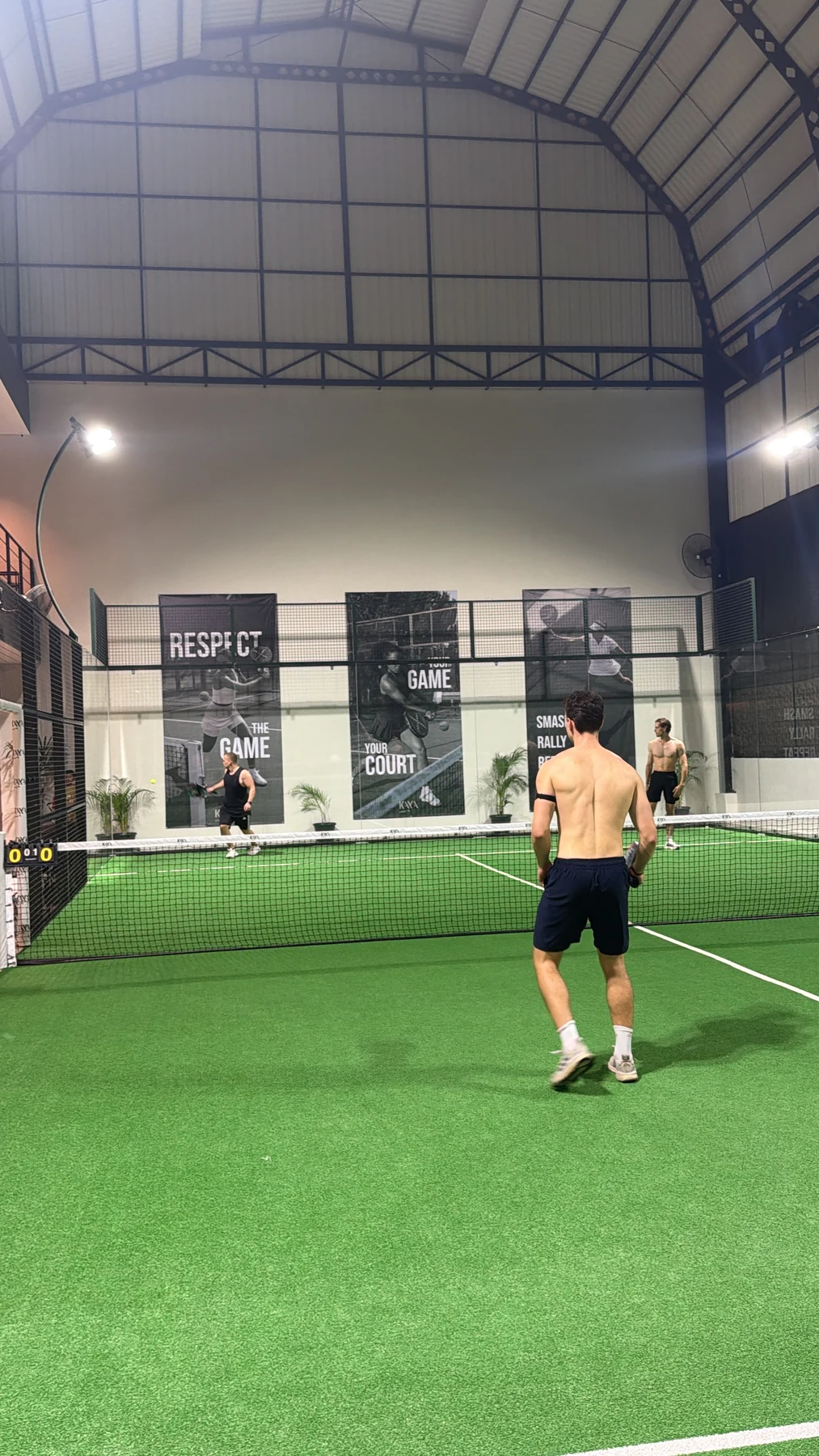 Mehrere Teilnehmer spielen Padel auf einem grünen Court auf Bali